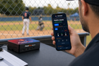 FieldFire Spark controller at a baseball operations desk with FieldFire Mobile Manual Control displayed on a phone.